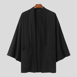 Dettaglio frontale del cardigan nero da uomo con maniche a pipistrello e tasche