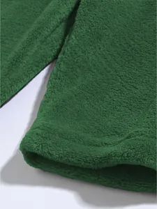 Nahaufnahme der weichen grünen Korallenfleece-Textur dieser lässigen Freizeitshorts für Herren