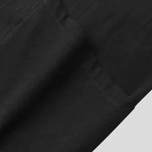 Texture dettagliata del tessuto di cotone nero con cuciture ordinate per cardigan uomo.