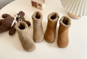 Détail de deux paires de bottes d'hiver pour enfants doublées de polaire en marron et kaki.
