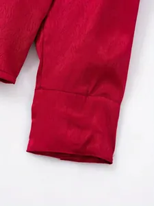 Gros plan sur la texture du tissu rouge mercerisé d'un poignet de chemise pour homme