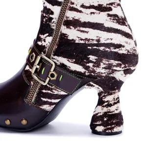Close-up detail of handmade genuine leather boots featuring zebra print and buckle