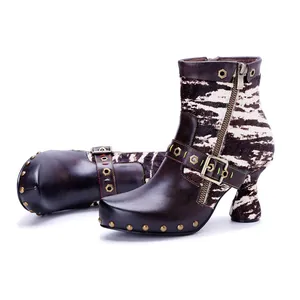 Detailed view of handmade leather boots with zebra print and bronze rivet accents