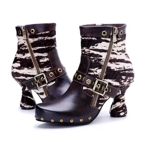 Detailed view of handmade leather boots featuring zebra print, buckles, and rivets.