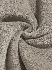 Close-up texture of soft beige coral fleece fabric for men's leisure shorts.