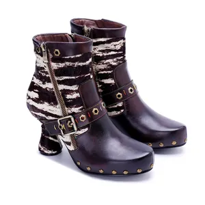 Detailed macro shot of leather patchwork ankle boots with zebra print and metal rivets