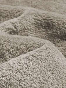 Detailed macro view of soft beige coral fleece fabric texture for men's casual shorts