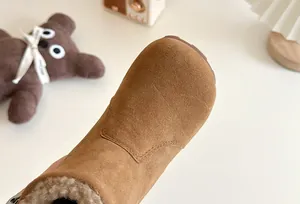 Gros plan de bottes d'hiver pour enfants en daim marron avec doublure en peluche
