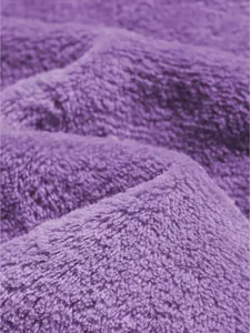 Close-up macro shot showcasing the ultra-soft texture of purple coral fleece fabric