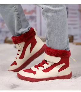 Detalle de las botas de invierno altas en rojo y crema para niños con forro de felpa