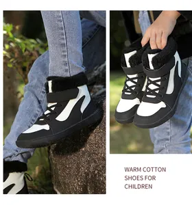 Detalle de botas de invierno cálidas para niños con forro de piel sintética negra.