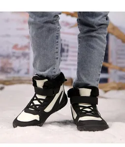 Primer plano de botas de invierno cálidas para niños en negro y blanco con forro de felpa