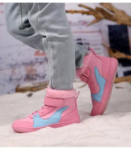 Primer plano de botas de invierno rosas para niños con forro de piel sintética cálida