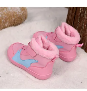 Vista detallada de botas de invierno rosas para niños con forro de piel sintética.