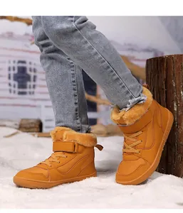 Botas de invierno cálidas amarillas con forro polar para niños en la nieve