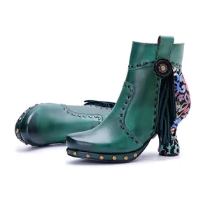 Detail of emerald green handmade leather ankle boots with floral patchwork and tassels.