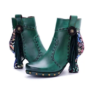 Detailed macro view of handmade green leather fringe boots with colorful floral patterns