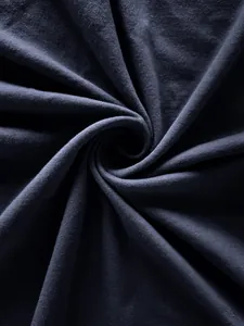 Gros plan montrant la texture douce et le tissage du tissu en maille de pur coton bleu marine.