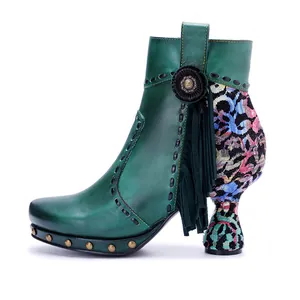 Detail view of green handmade rubbed leather ankle boot with floral print and fringe tassels