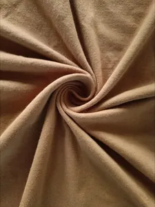 Vue macro montrant la texture douce et la maille fine du tissu en coton marron chameau