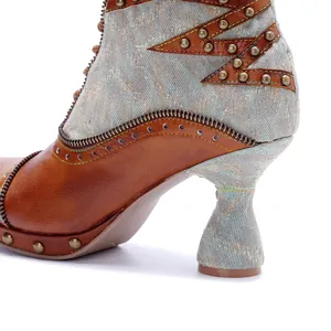 Vue détaillée de bottes biker en cuir vieilli et patchwork de denim avec des clous