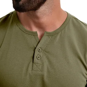 Détail rapproché d'un t-shirt Henley vert olive pour homme avec boutons et texture