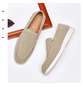 Close-up of beige suede men's loafers featuring white stitching and slip-on design