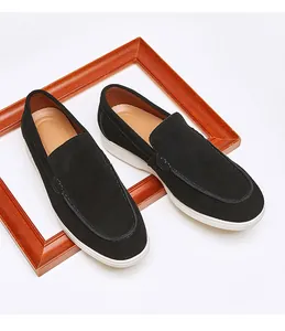 Close-up detail of stylish black suede loafers with white soles on a white background