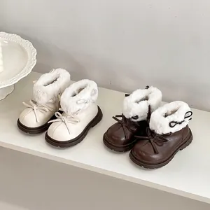 Detalle de botas de invierno de cuero para niña en beige y marrón con ribete de pelo