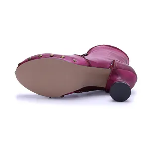 Detailed macro view of fuchsia brushed leather boot with studded sole and round heel
