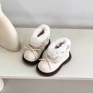 Primer plano de botas de invierno beige para niños con pelo sintético y decoración