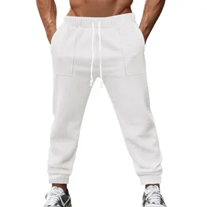 Detailed view of men's white knitted joggers featuring cable pattern and drawstring waist