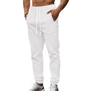 Detail view of men's white knit joggers featuring textured pattern and drawstring waist