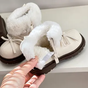 Detalle de botas de invierno blancas para niña con forro de piel gruesa y lazo lateral