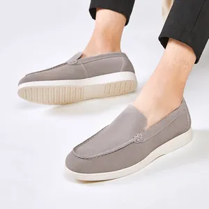 Comfortable men's grey suede slip-on loafers in casual British style with a white sole