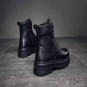 Vue arrière de bottines de combat en cuir noir avec semelles épaisses et zip latéral.