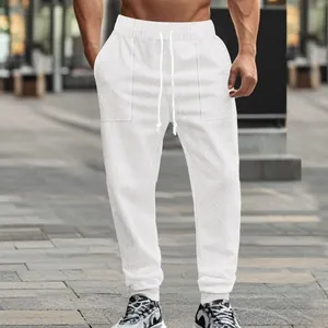 Detailed view of white textured knit joggers with drawstring and ribbed ankle cuffs.