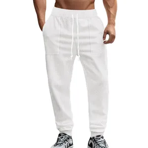 Detail shot of white men's knit joggers with drawstring waist and textured pattern