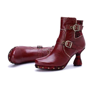 Detailed view showing the vintage leather texture and floral heel design of these boots