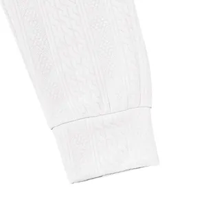 Close-up of white knitted men's jogger pants with textured jacquard pattern