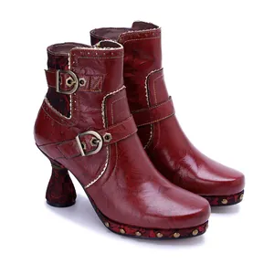 Macro view of vintage red leather ankle boots with floral patterns and buckles for women