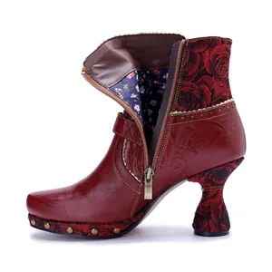 Detailed side view of handmade red leather boots with floral print and durable metal zipper