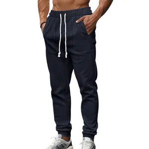 Detail view of men's navy blue knitted joggers with textured pattern and drawstring
