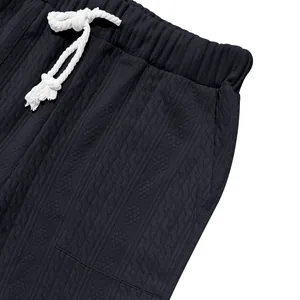 Close-up detail of men's navy knit sports pants showing weave texture and drawstring