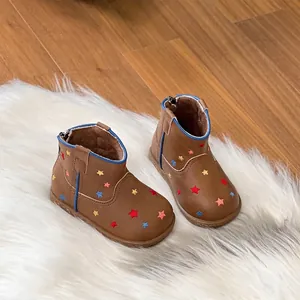 Detailed view of brown toddler boots with colorful star patterns and cozy fur lining.