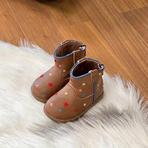 Detailed view of brown toddler Martin boots with colorful star patterns on white faux fur