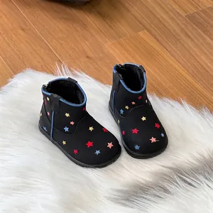 Detailed view of black children's winter boots with colorful star embroidery and lining