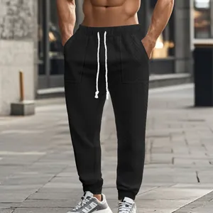Close-up of men's black knitted textured joggers with white drawstring and cuff detail.
