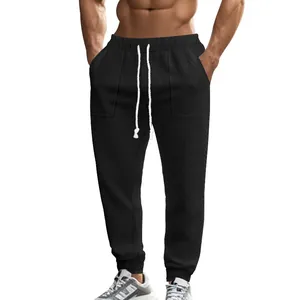 Detailed view of men's black knitted joggers featuring drawstring waist and textured fabric