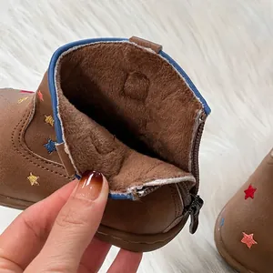 Detailed macro view showing the warm and soft plush brown lining inside kids leather winter boots